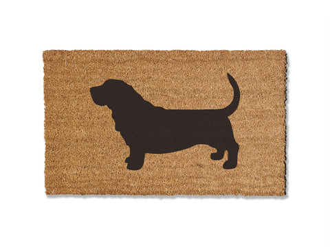 A coir doormat that is 18 inches by 30 inches and has the silhouette of a basset hound painted on it.